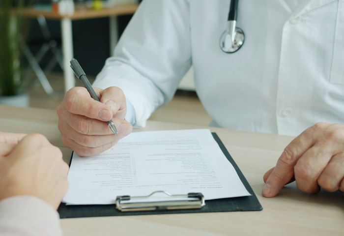 Eine medizinische Fachperson füllt ein Patientenformular aus