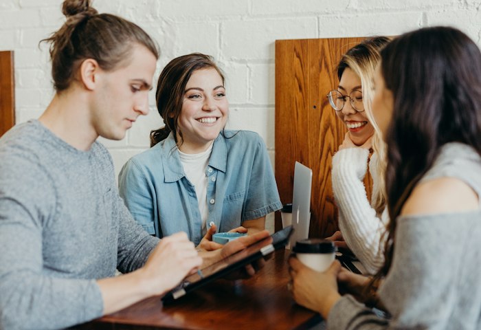Eine Gruppe junger Erwachsener unterhält sich an einem Tisch